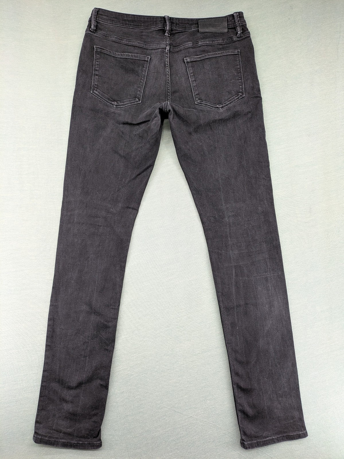 Jack & Jones black slim fit jeans faded wash stretch denim with logo detail.