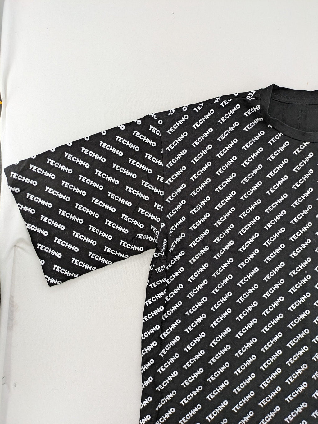 Fresh Cut black techno t-shirt all-over print with bold "TECHNO" graphic design.