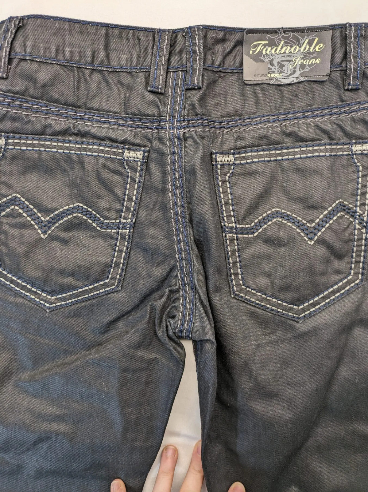 Fadnoble grey straight jeans with button fly and contrasting stitching details.