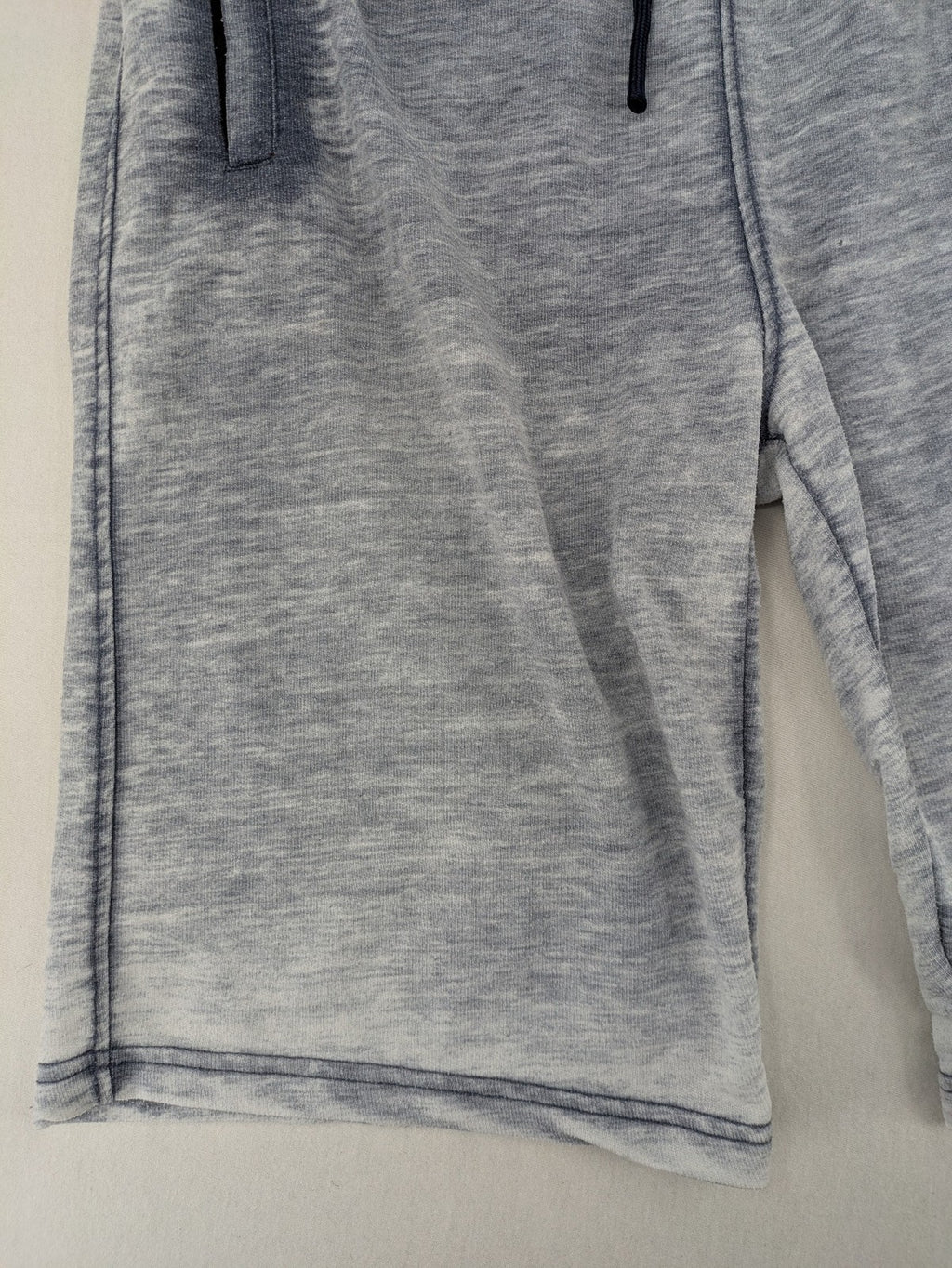 Nike grey acid wash jogger shorts with embossed logo and zip pockets.
