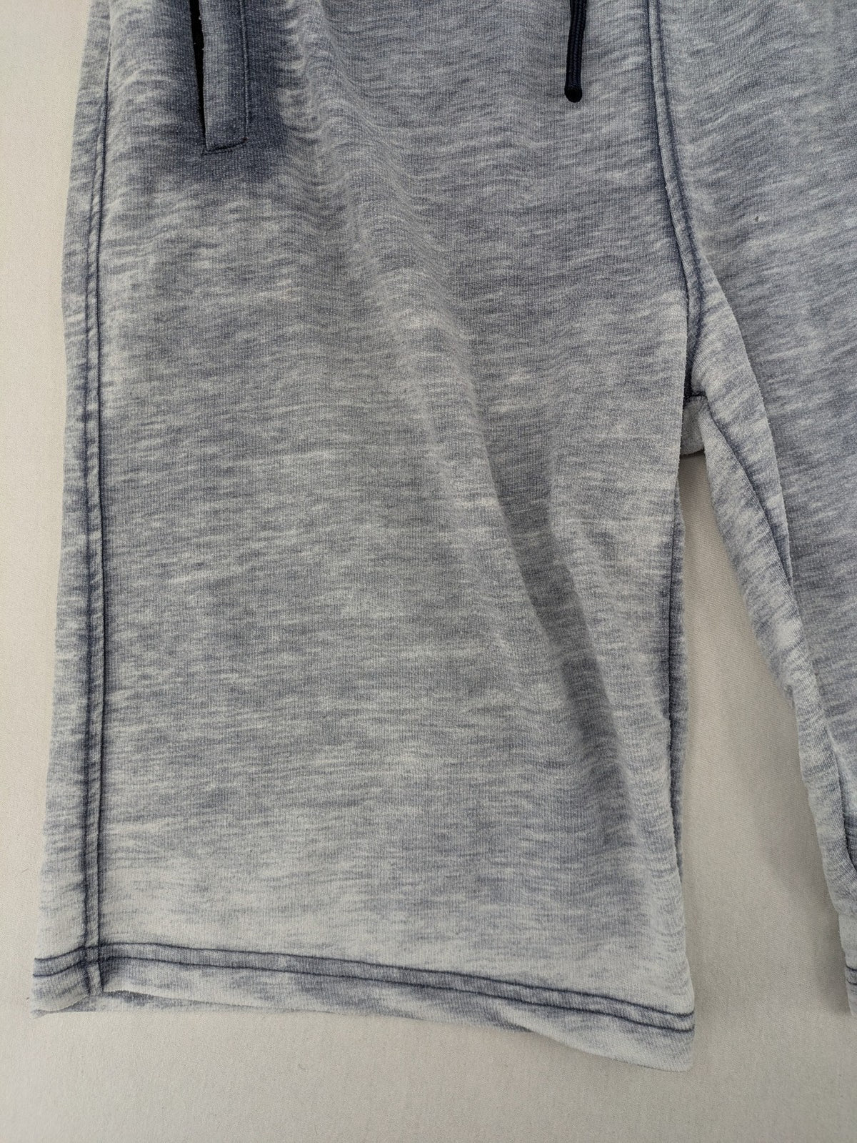 Nike grey acid wash jogger shorts with embossed logo and zip pockets.