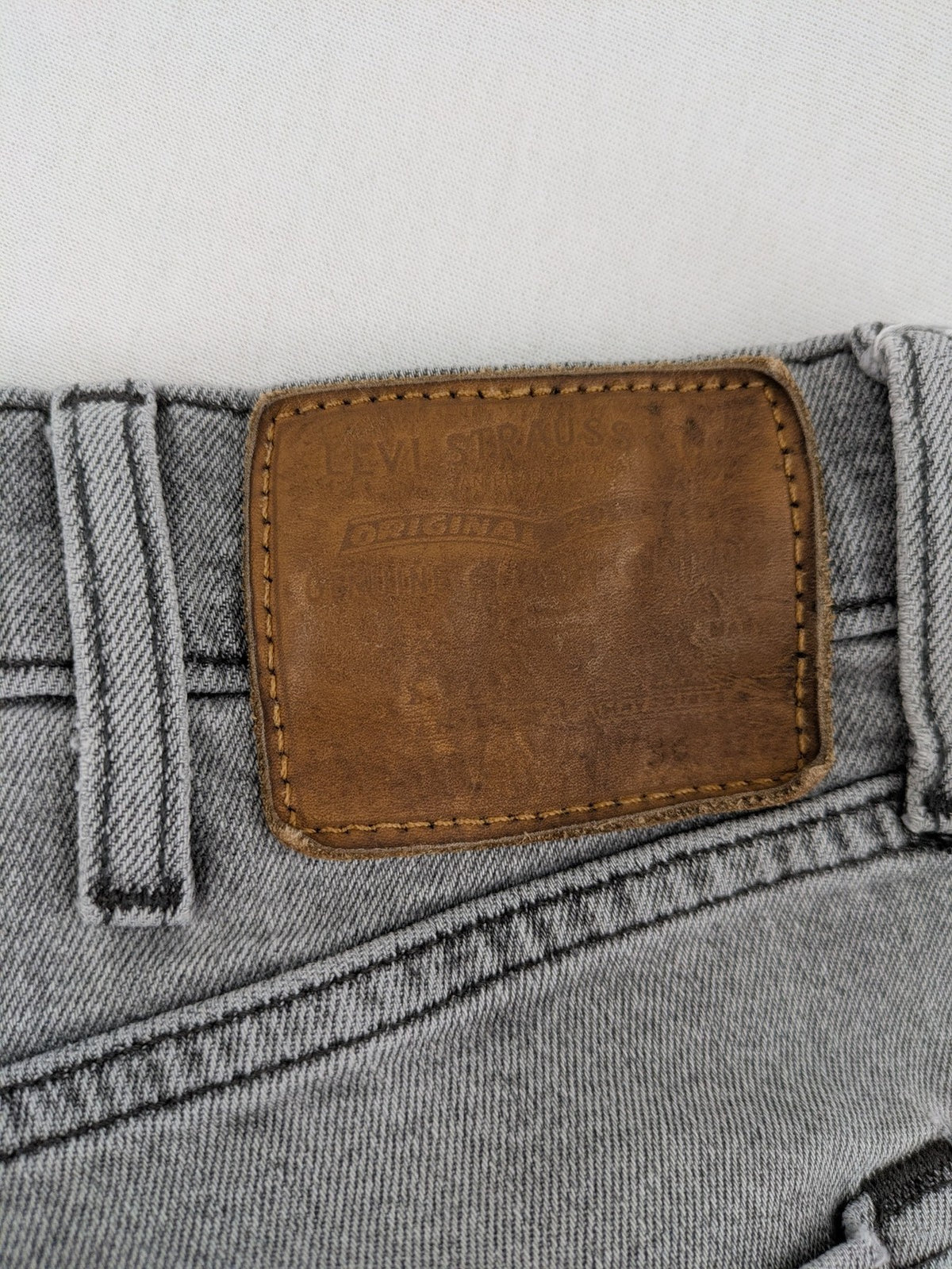 Levi's grey slim fit jeans with distressed knee details and classic logo patch.