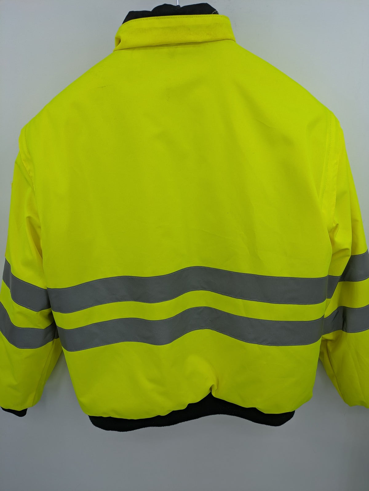 Hüren OHG grey and neon yellow safety jacket with reflective stripes and zippered arm pocket.