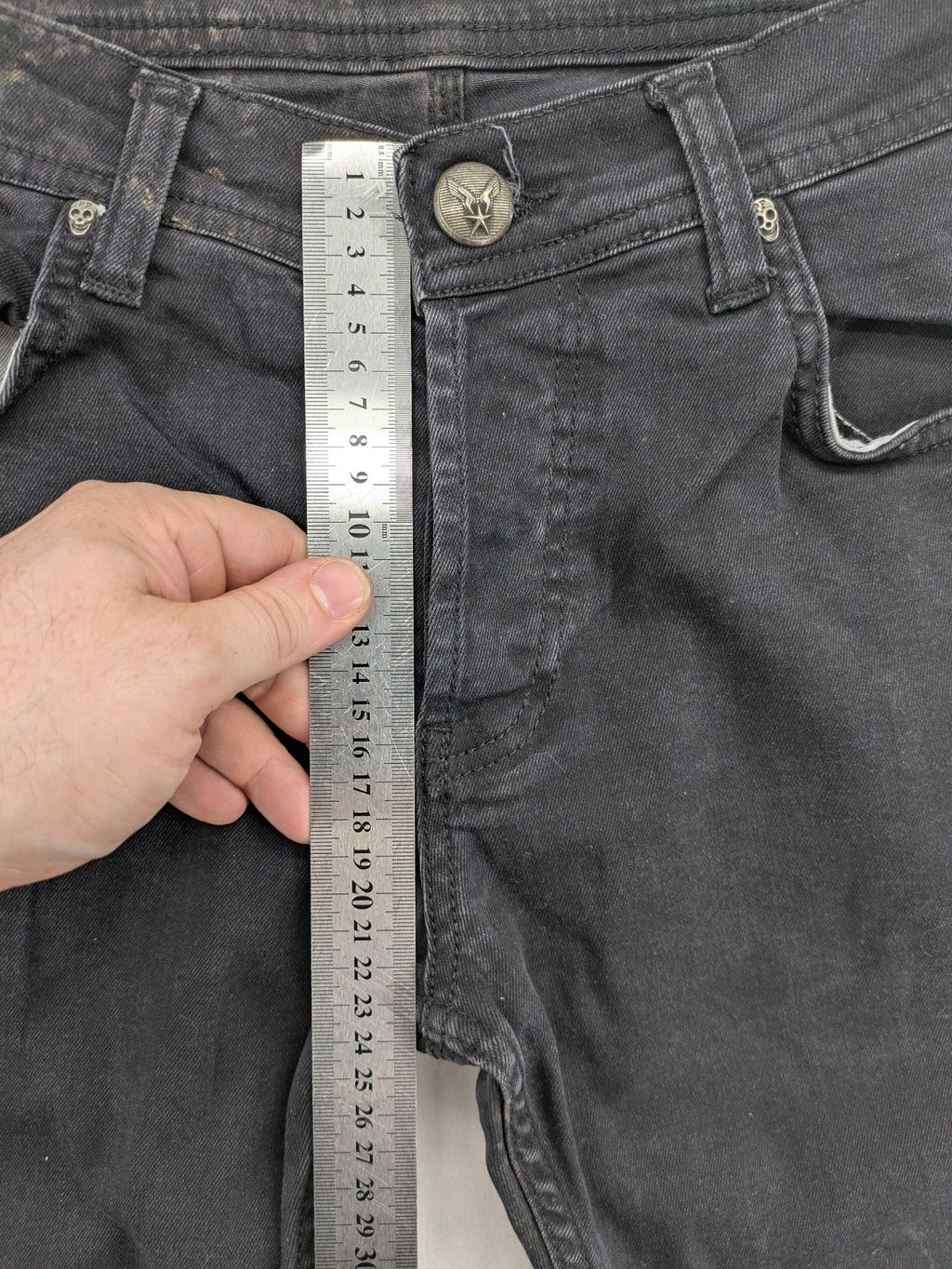 Philipp Plein black straight jeans with distressed finish and skull patch detail.