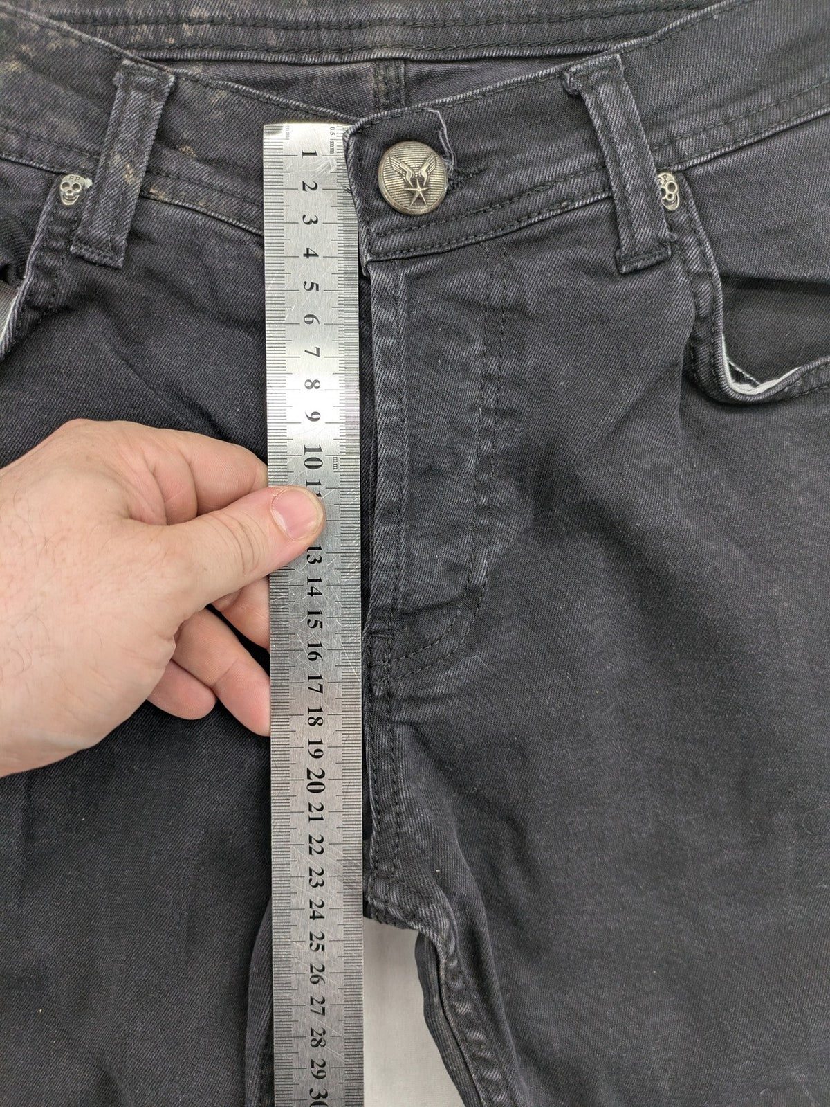 Philipp Plein black straight jeans with distressed finish and skull patch detail.