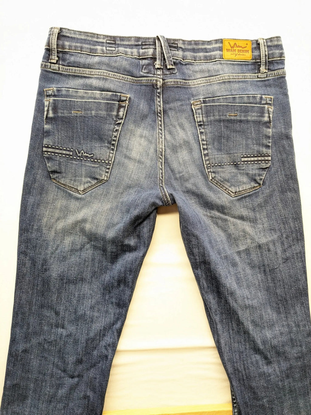 WAM Denim blue straight jeans with distressed details and button fly.