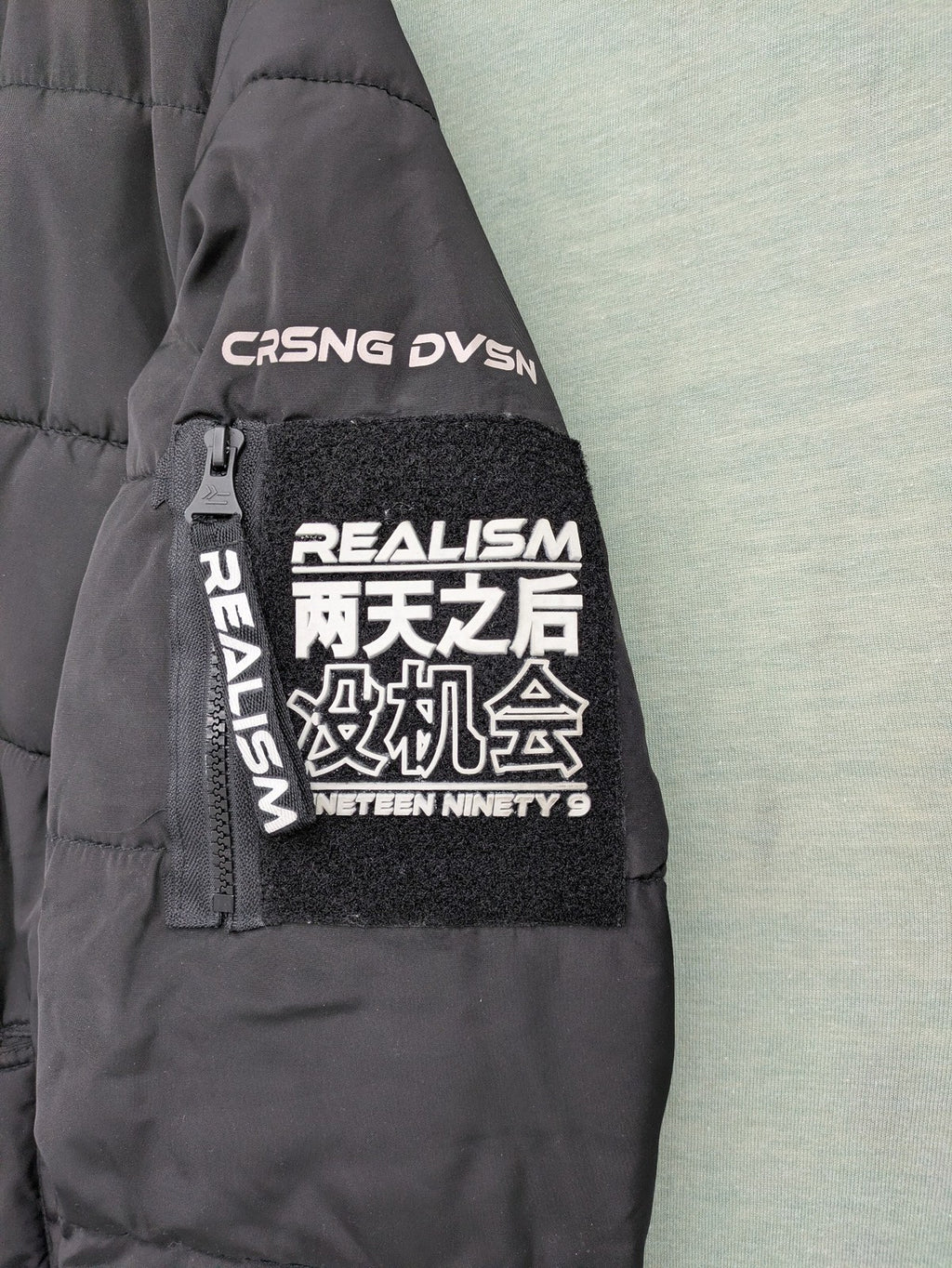 Chapter black bomber jacket with patches, striped ribbed cuffs, and full zip closure.