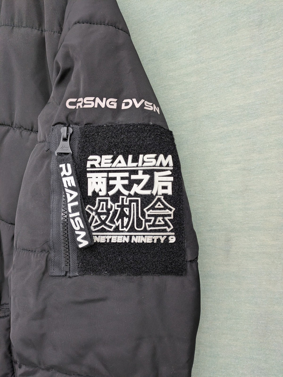 Chapter black bomber jacket with patches, striped ribbed cuffs, and full zip closure.