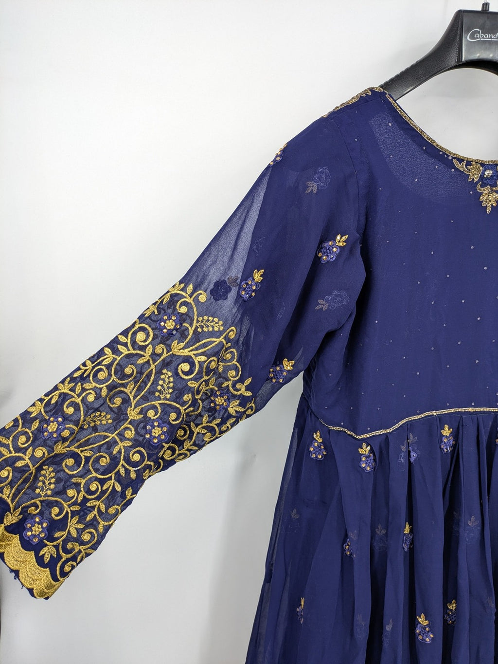 Bollywood bridal party dress gold with intricate blue embroidery and flowing Anarkali silhouette.