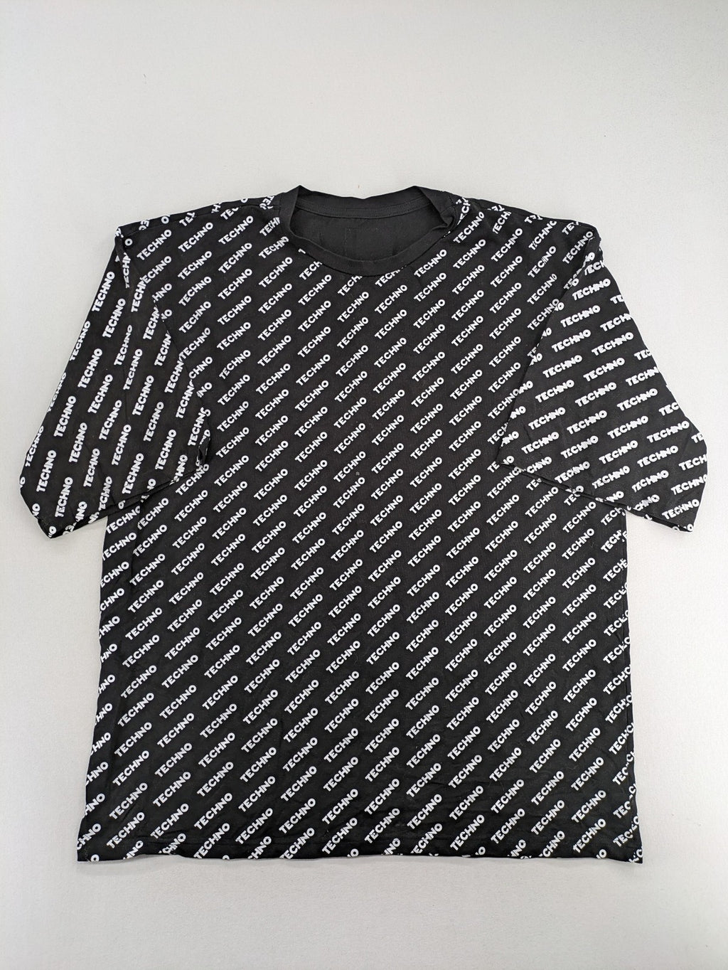 Fresh Cut black techno t-shirt all-over print with bold "TECHNO" graphic design.