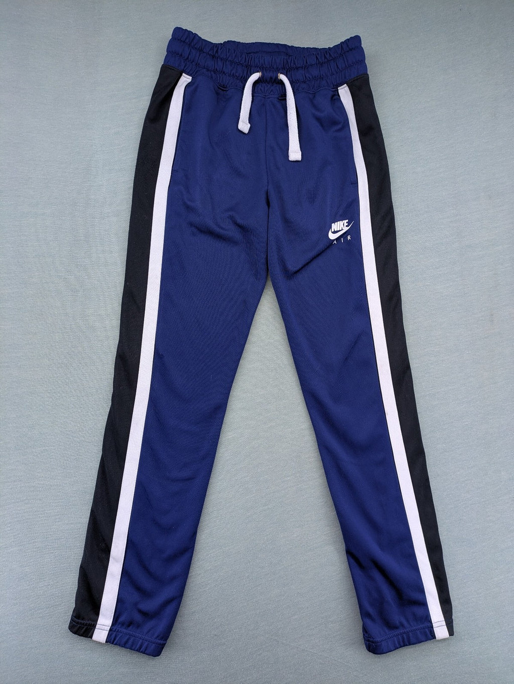 Nike Air blue jogging pants with black and white side stripes, elastic waistband.