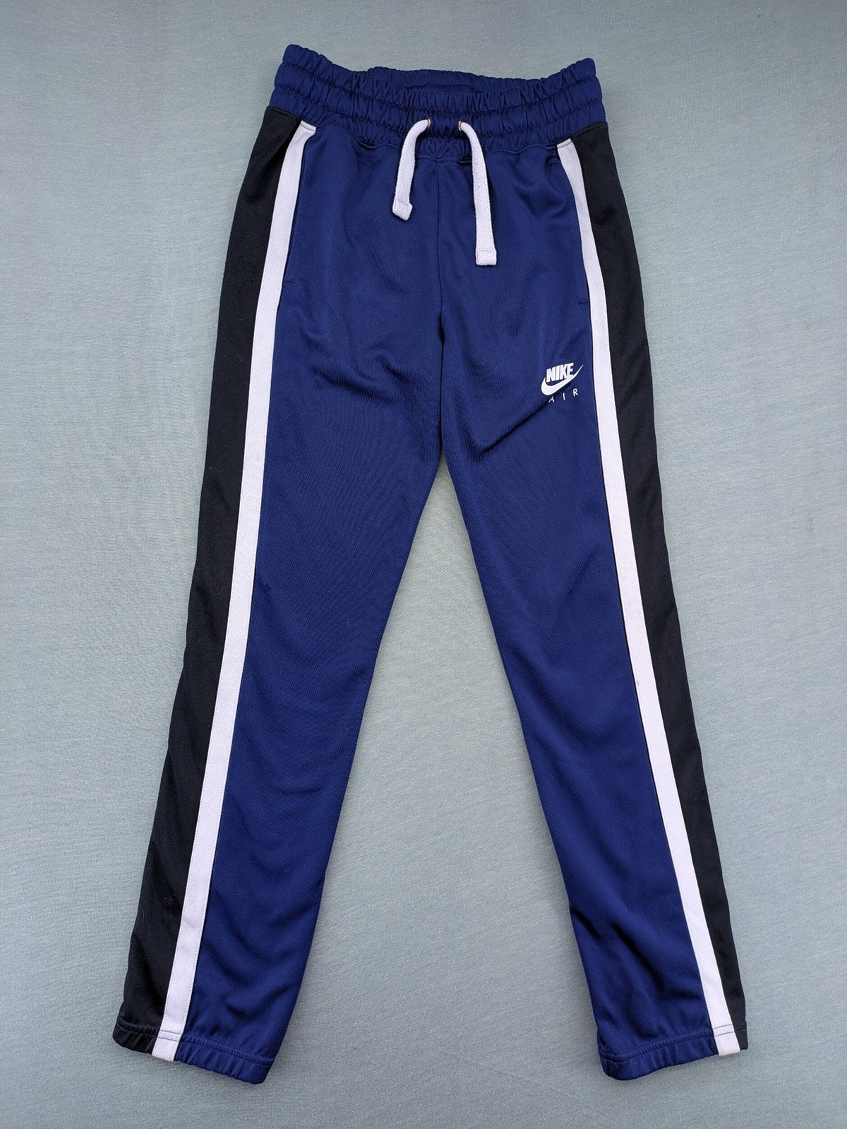 Nike Air blue jogging pants with black and white side stripes, elastic waistband.