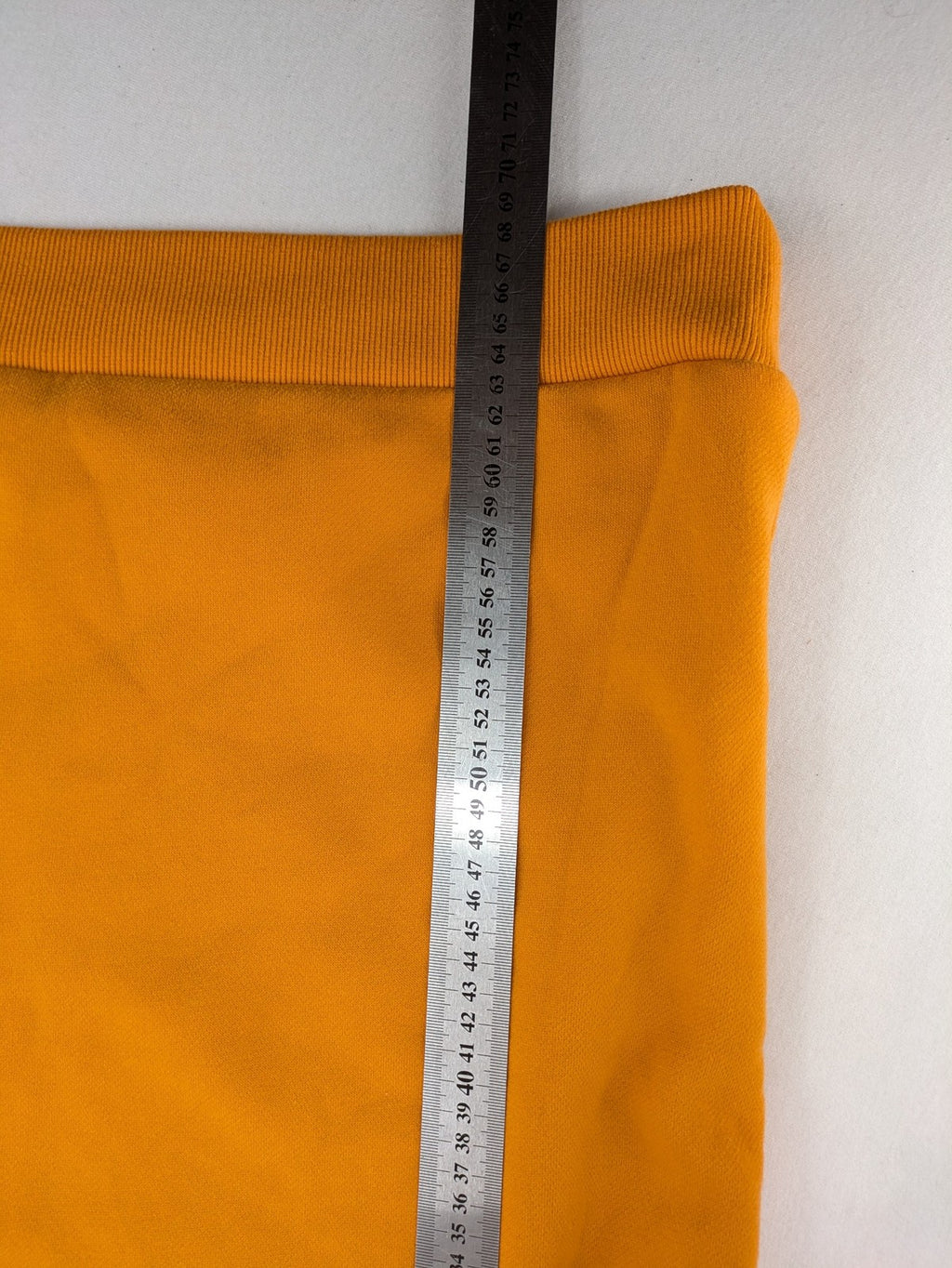 Superdry orange turtle neck jumper with textured logo patch and number 7 detail.