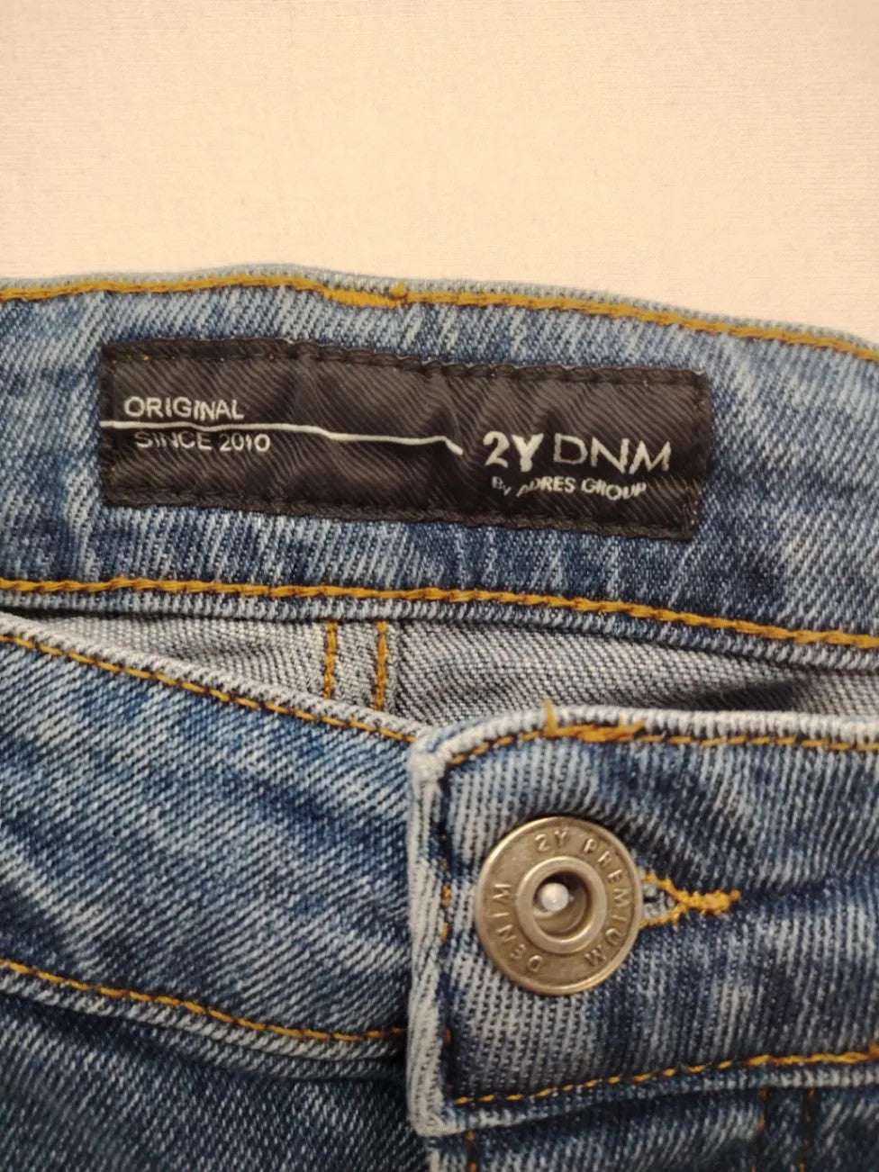 Damen blue skinny jeans with ripped details, five-pocket style, and classic button closure.