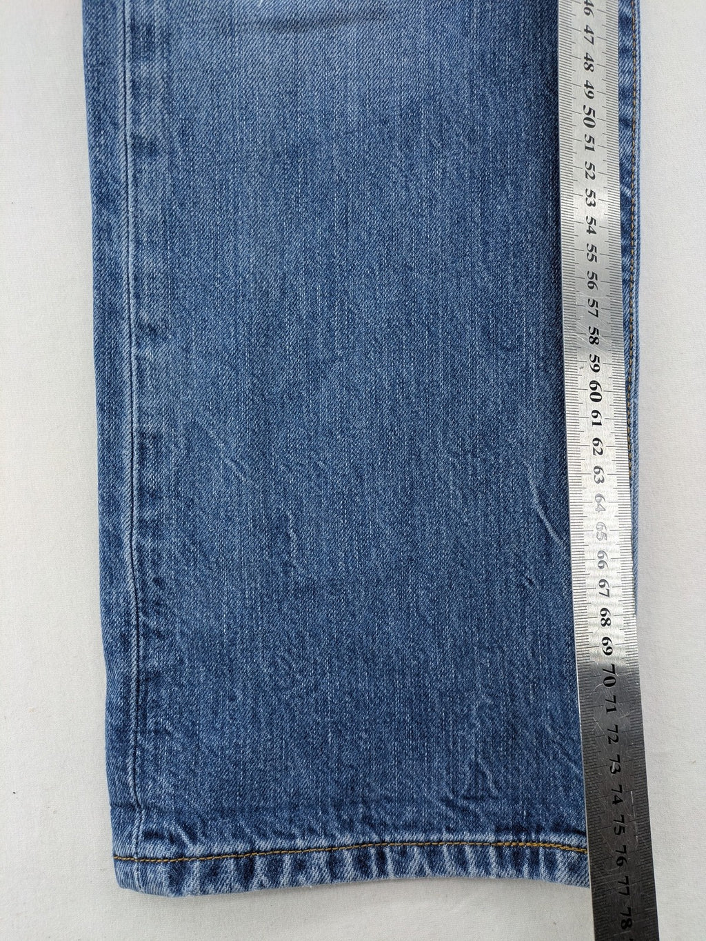 Levi's blue straight jeans with button-fly and distressed knee rips.