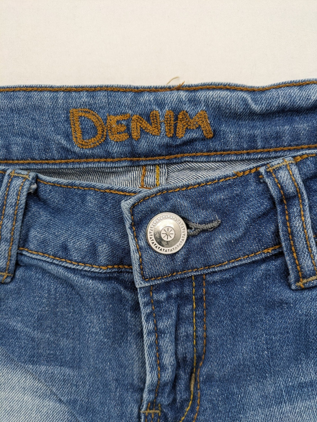 Denim blue straight jeans low rise bootcut with classic 5-pocket design and subtle rivets.
