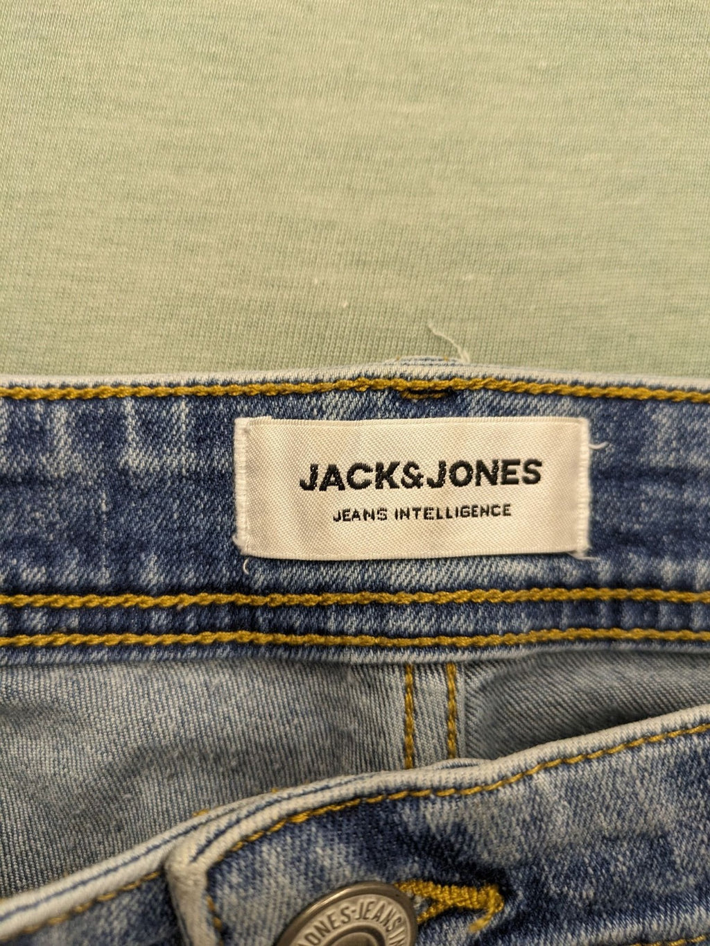 Jack & Jones blue slim fit jeans with button fly and light wash denim texture.