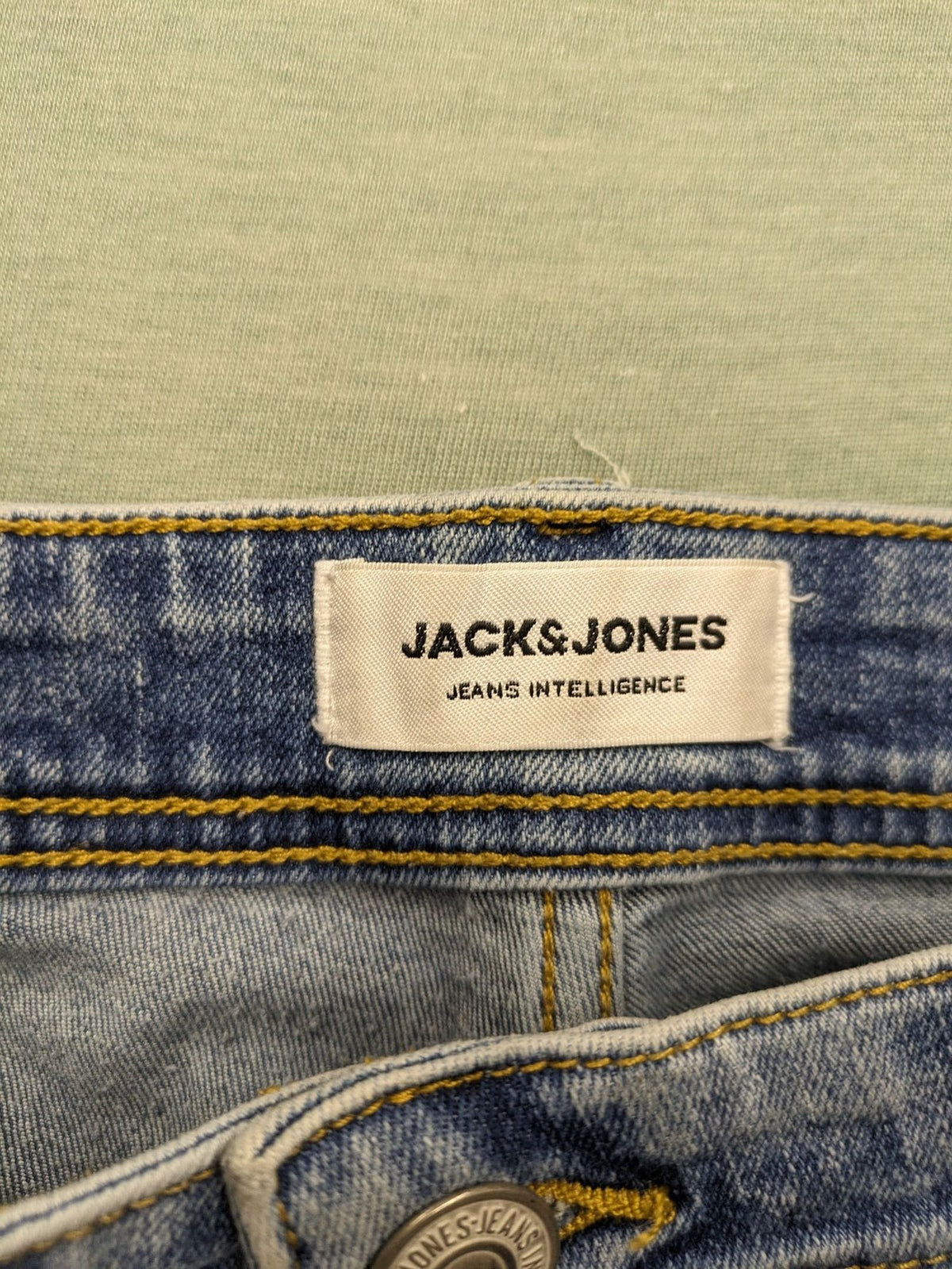 Jack & Jones blue slim fit jeans with button fly and light wash denim texture.