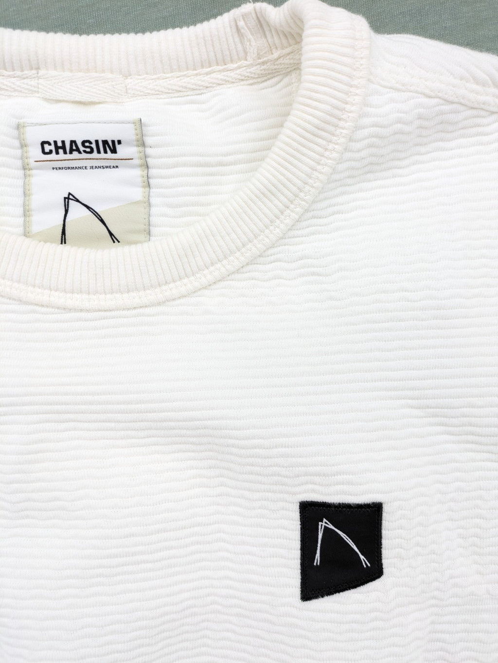 CHASIN' grey and white turtle neck jumper with horizontal ribbed texture and logo patch.