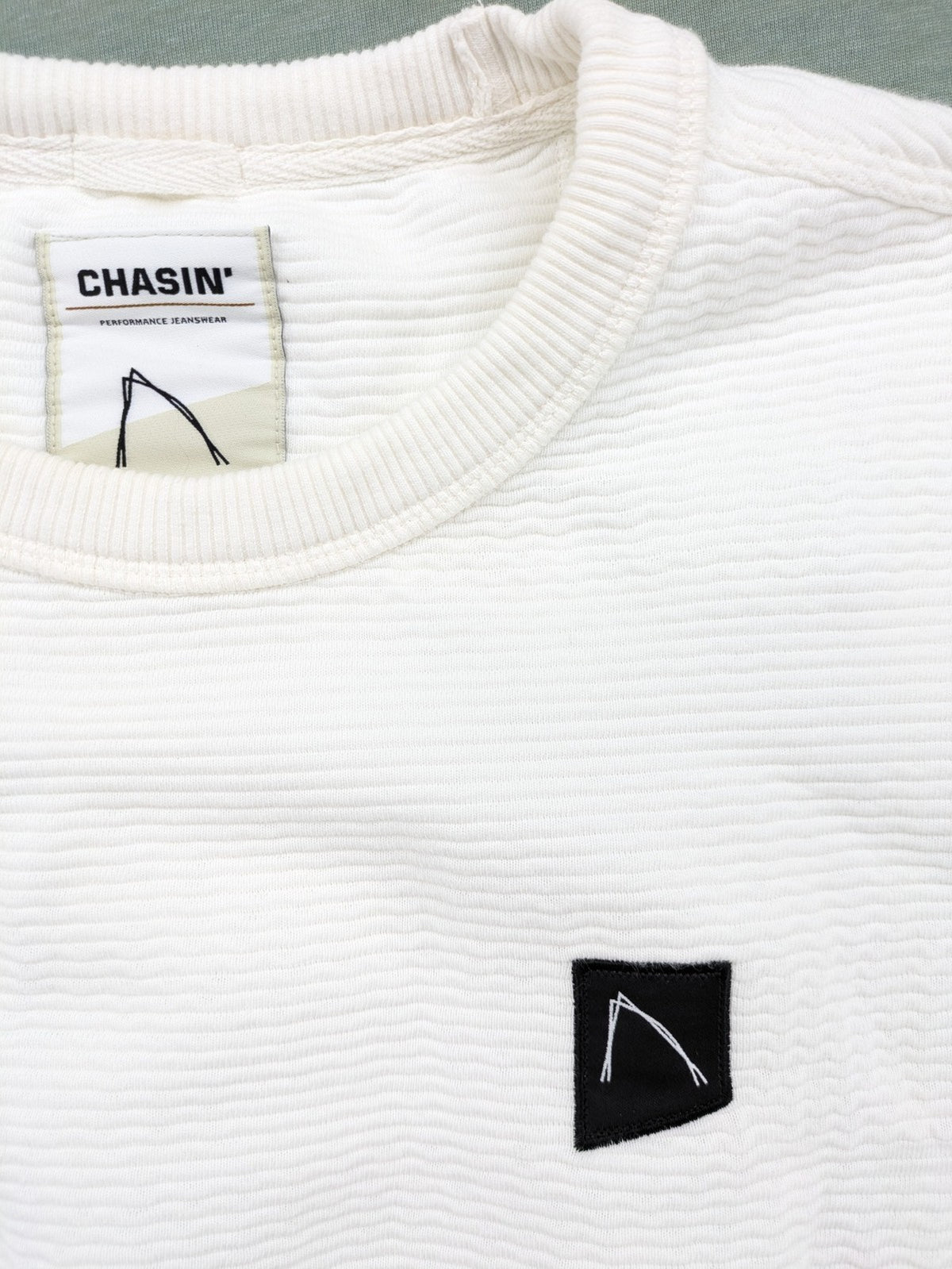 CHASIN' grey and white turtle neck jumper with horizontal ribbed texture and logo patch.