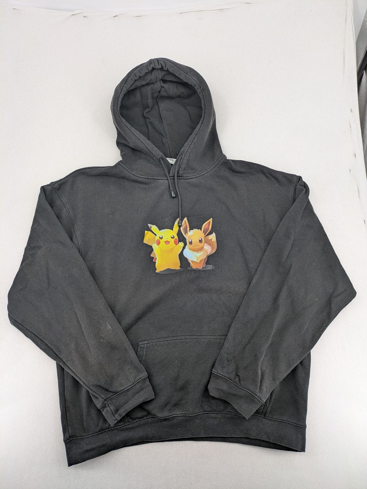 Pokémon black hoodie featuring colorful Pikachu and Evoli graphic, classic pullover style.
