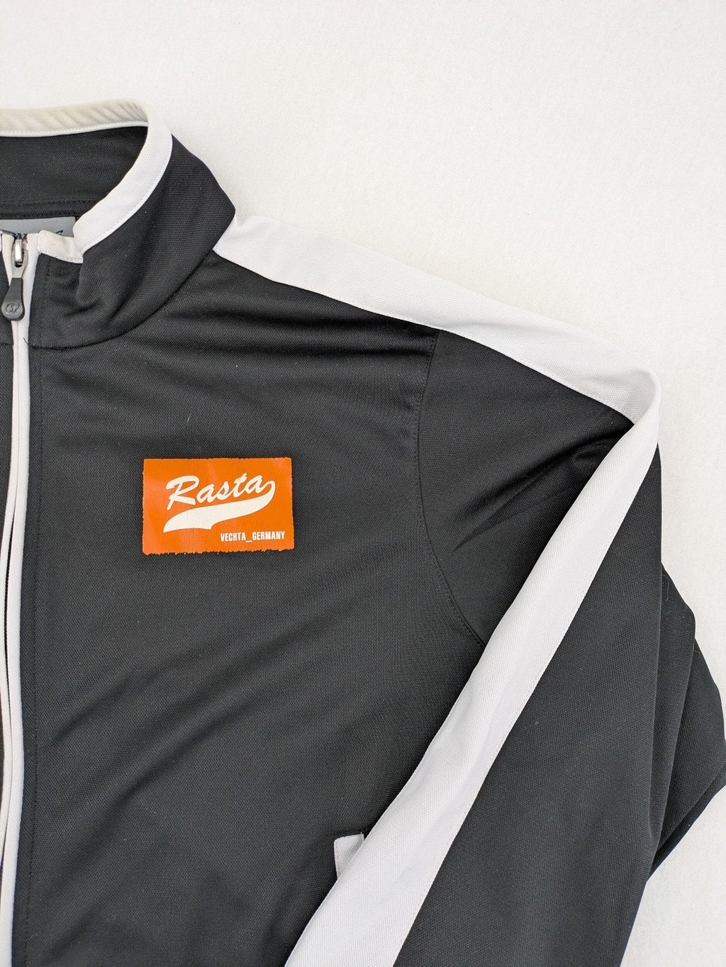 Spalding black training jacket with orange and white accents, Rasta Vechta logo, zip front.