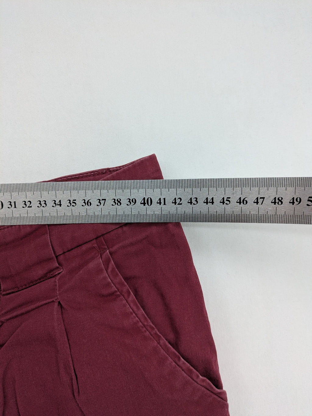 BPC Bonprix burgundy chino pants with front pleats and floral pocket lining.