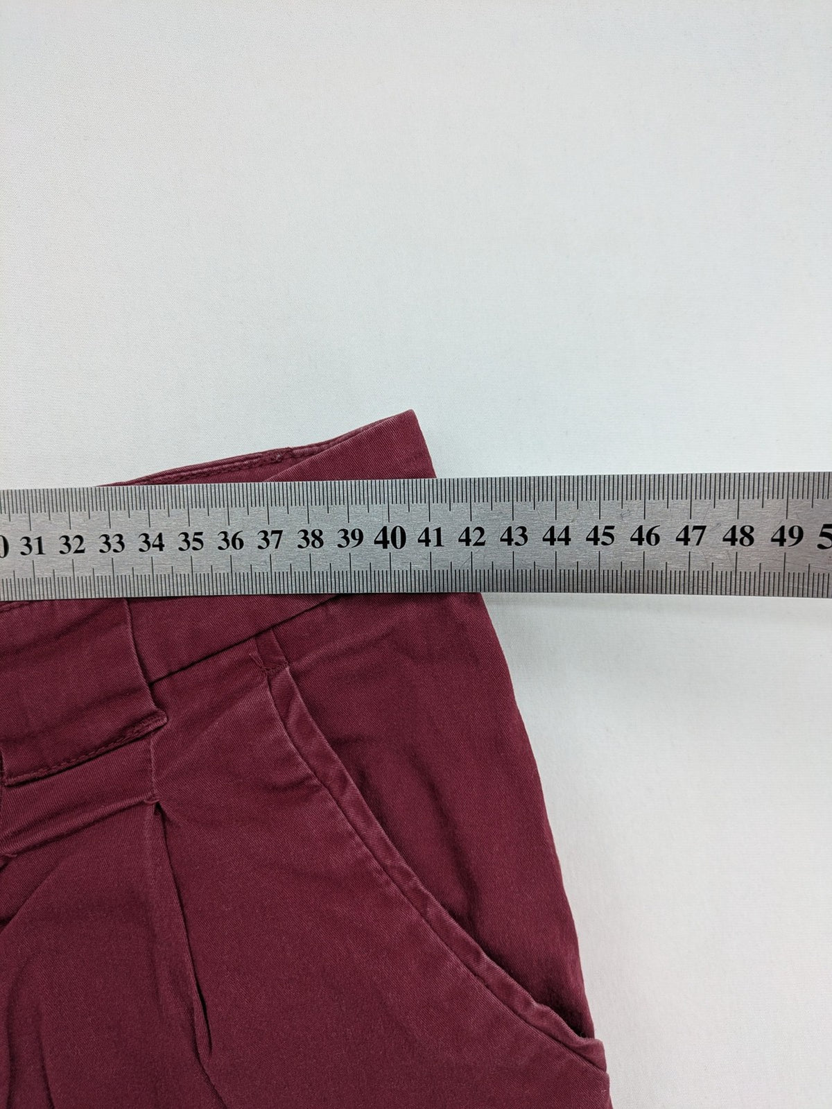BPC Bonprix burgundy chino pants with front pleats and floral pocket lining.