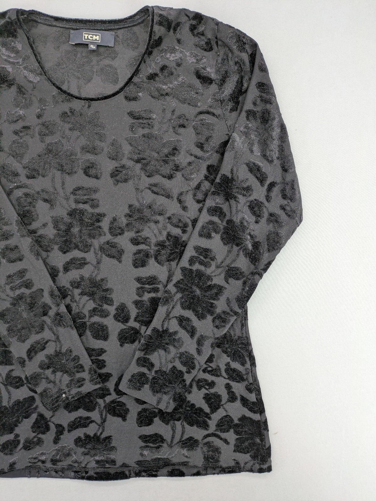 TCM black long sleeve top with floral flock print on sheer fabric.