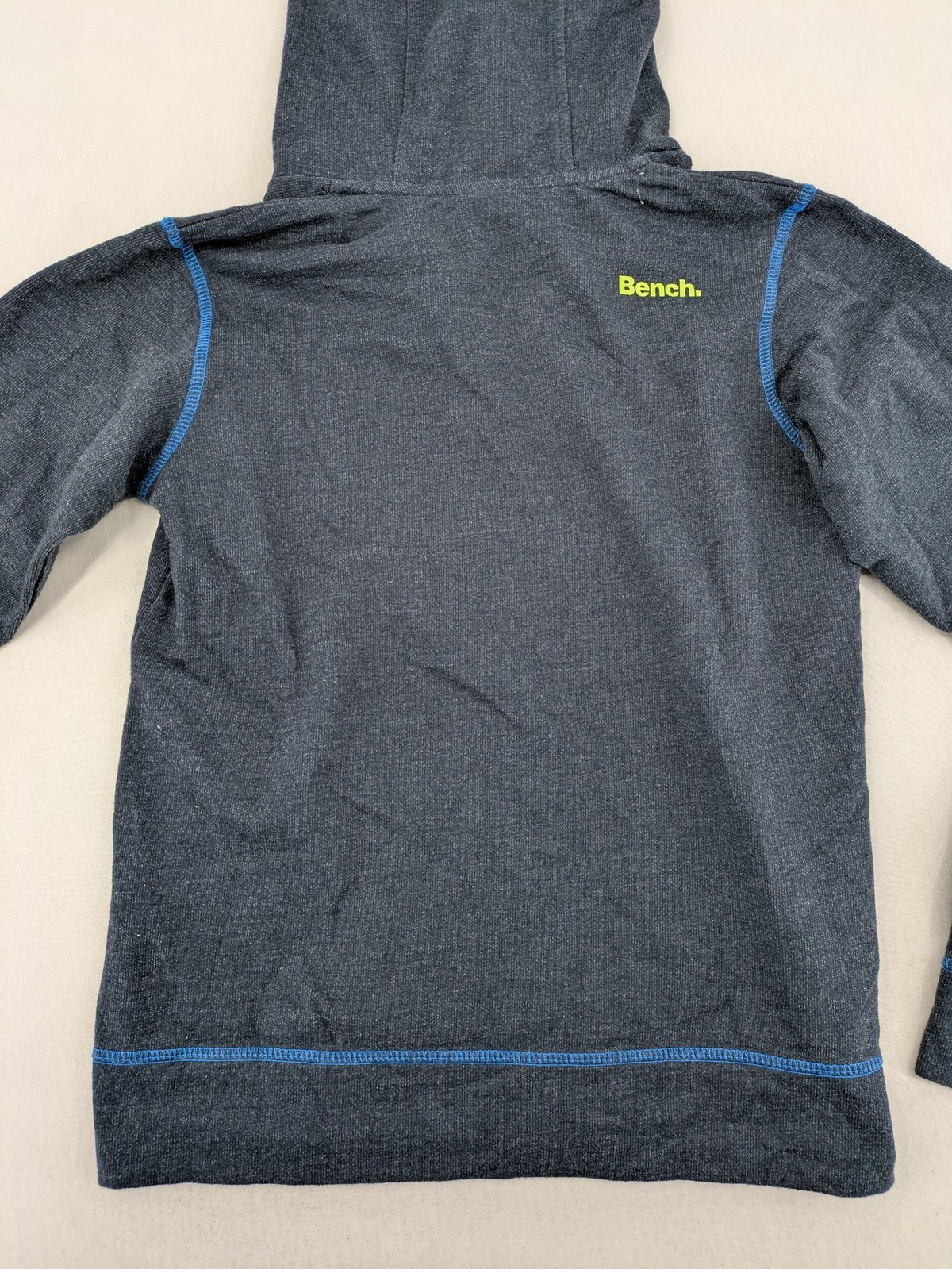 Bench hoodie dark grey with neon green logo and blue contrast stitching.