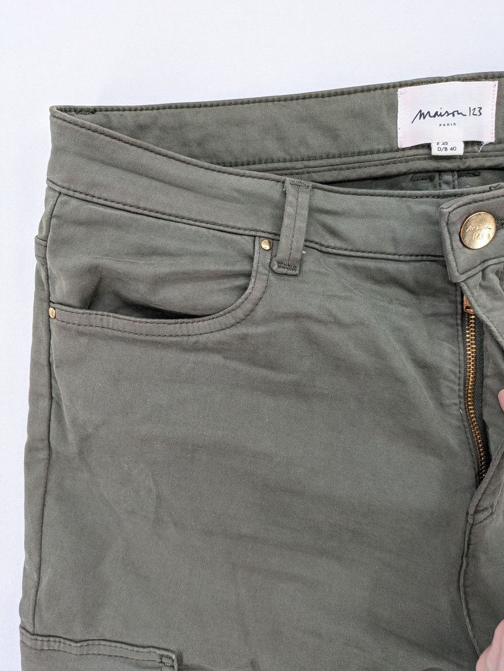 Maison 123 green cargo pants with ankle zippers and gold metal details.
