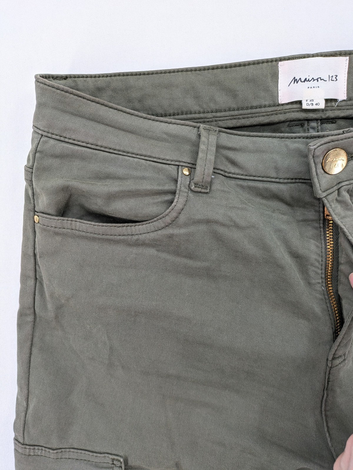 Maison 123 green cargo pants with ankle zippers and gold metal details.