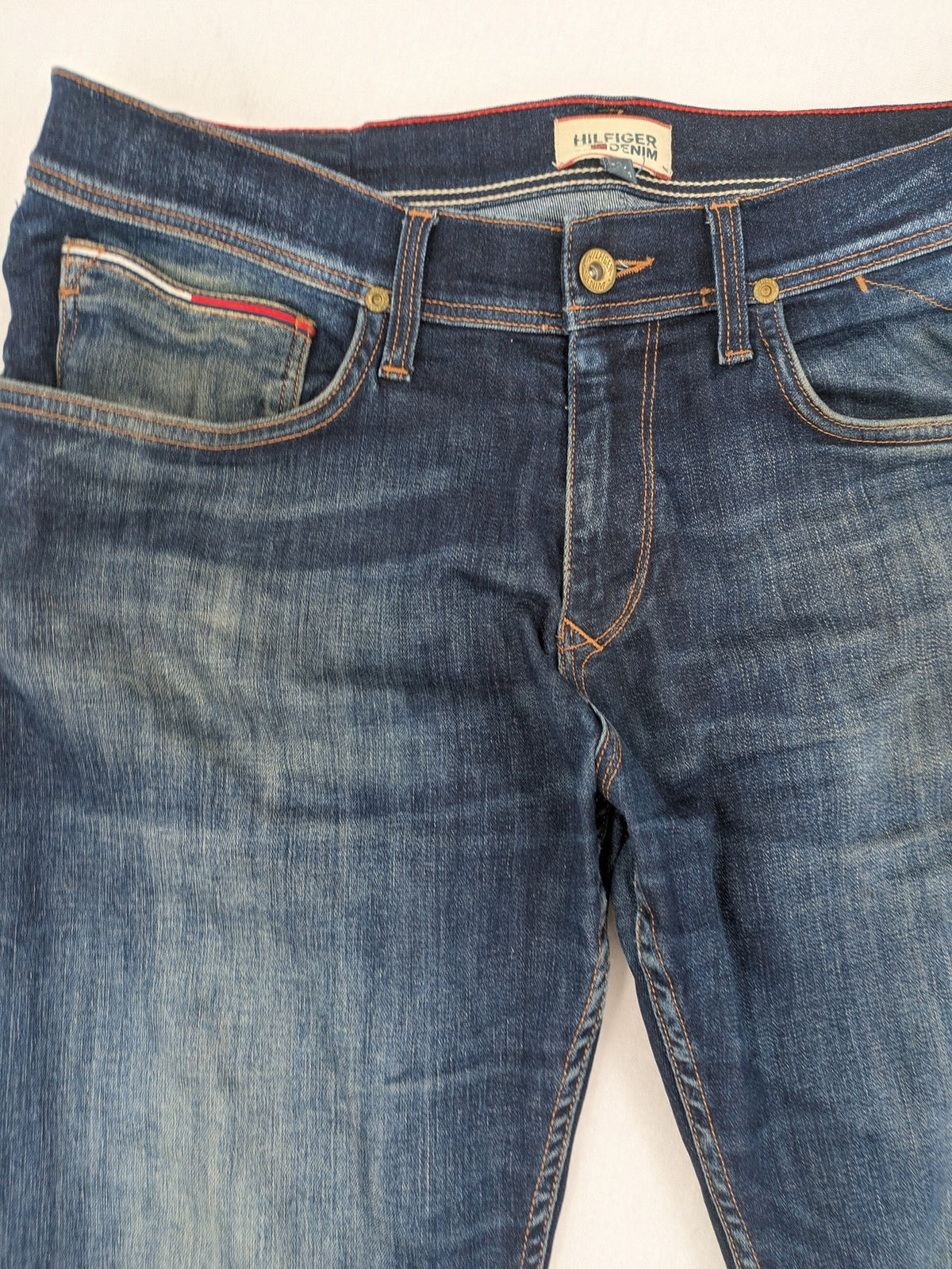 Tommy Hilfiger Denim blue straight jeans with five-pocket design and natural fading details.