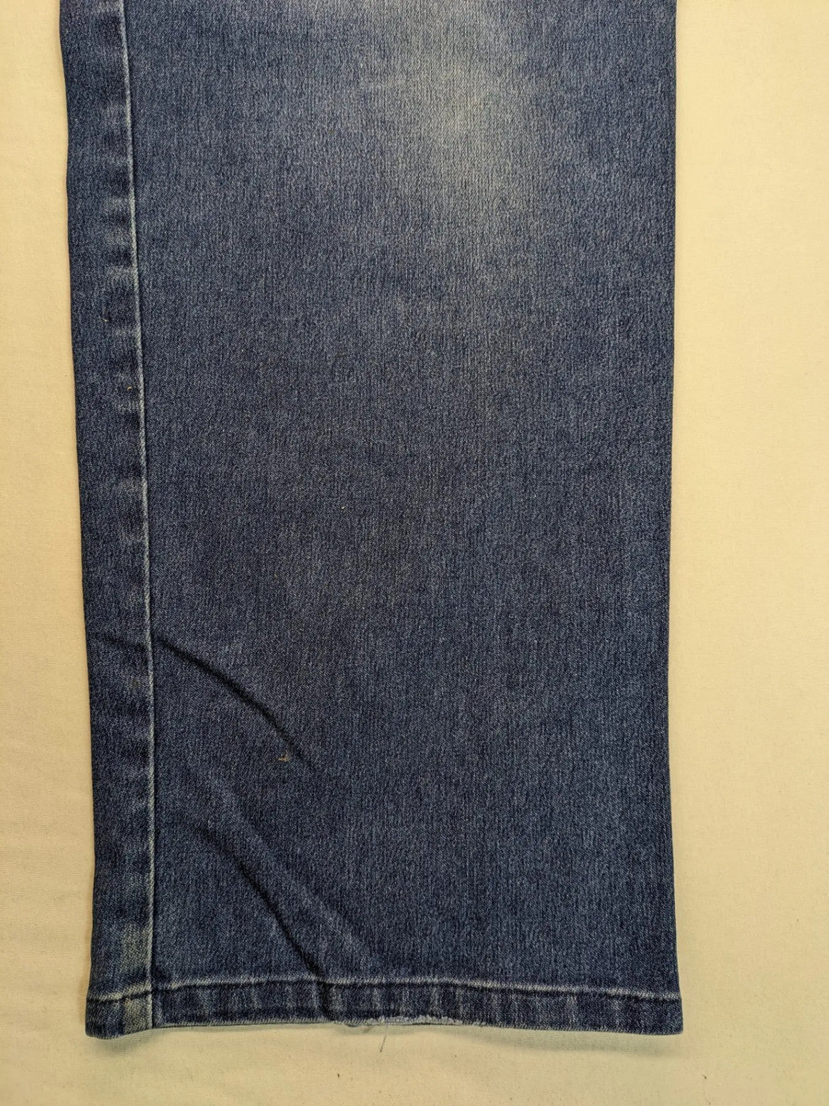 REI blue straight jeans with front pleats, zip fly, and buttoned back pockets.