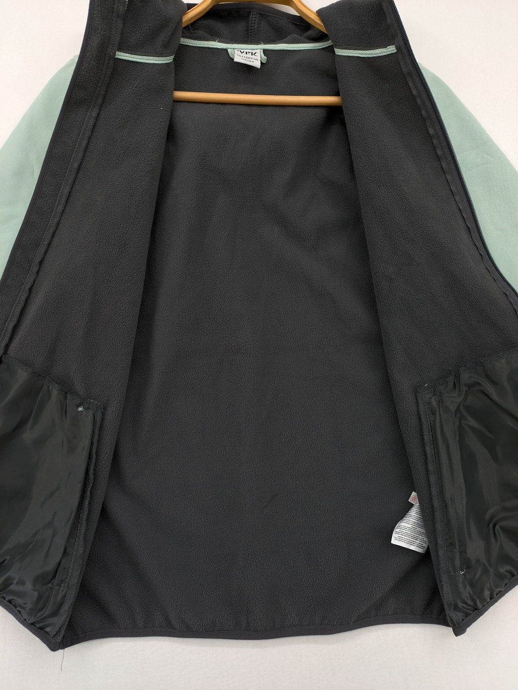 YFK outdoor jacket mint green softshell with dark grey fleece lining and hood.