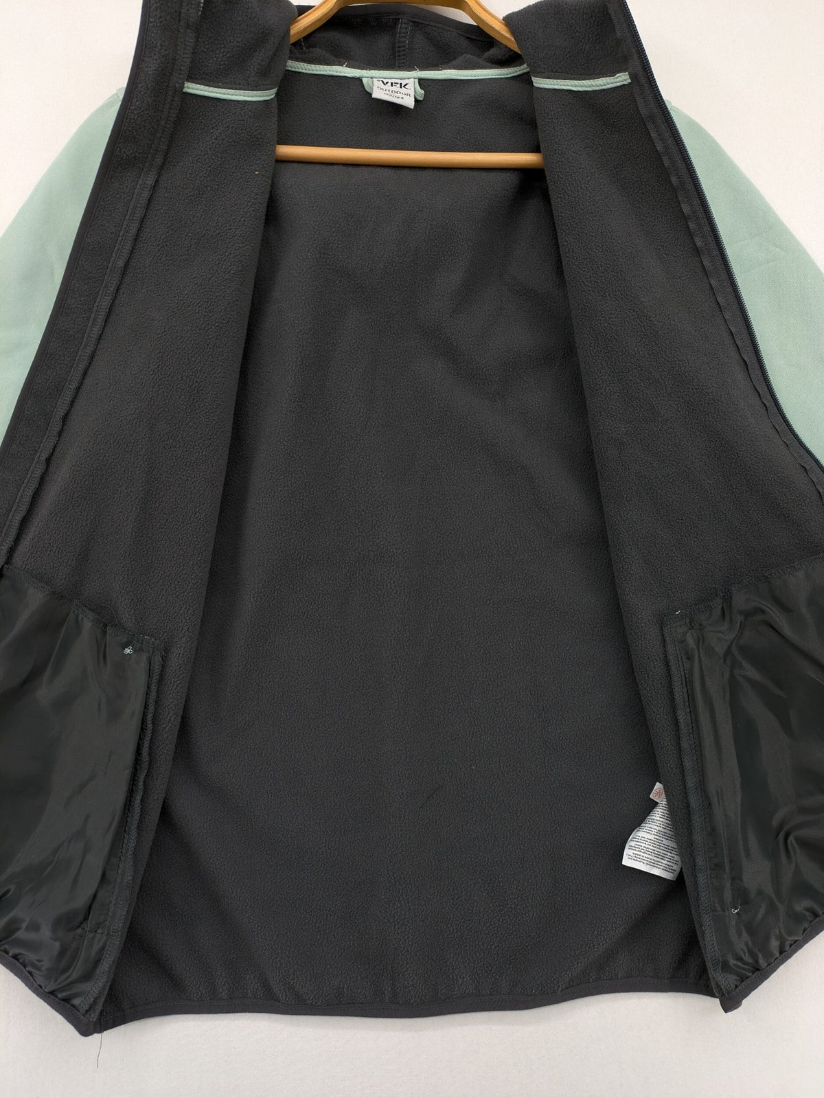 YFK outdoor jacket mint green softshell with dark grey fleece lining and hood.