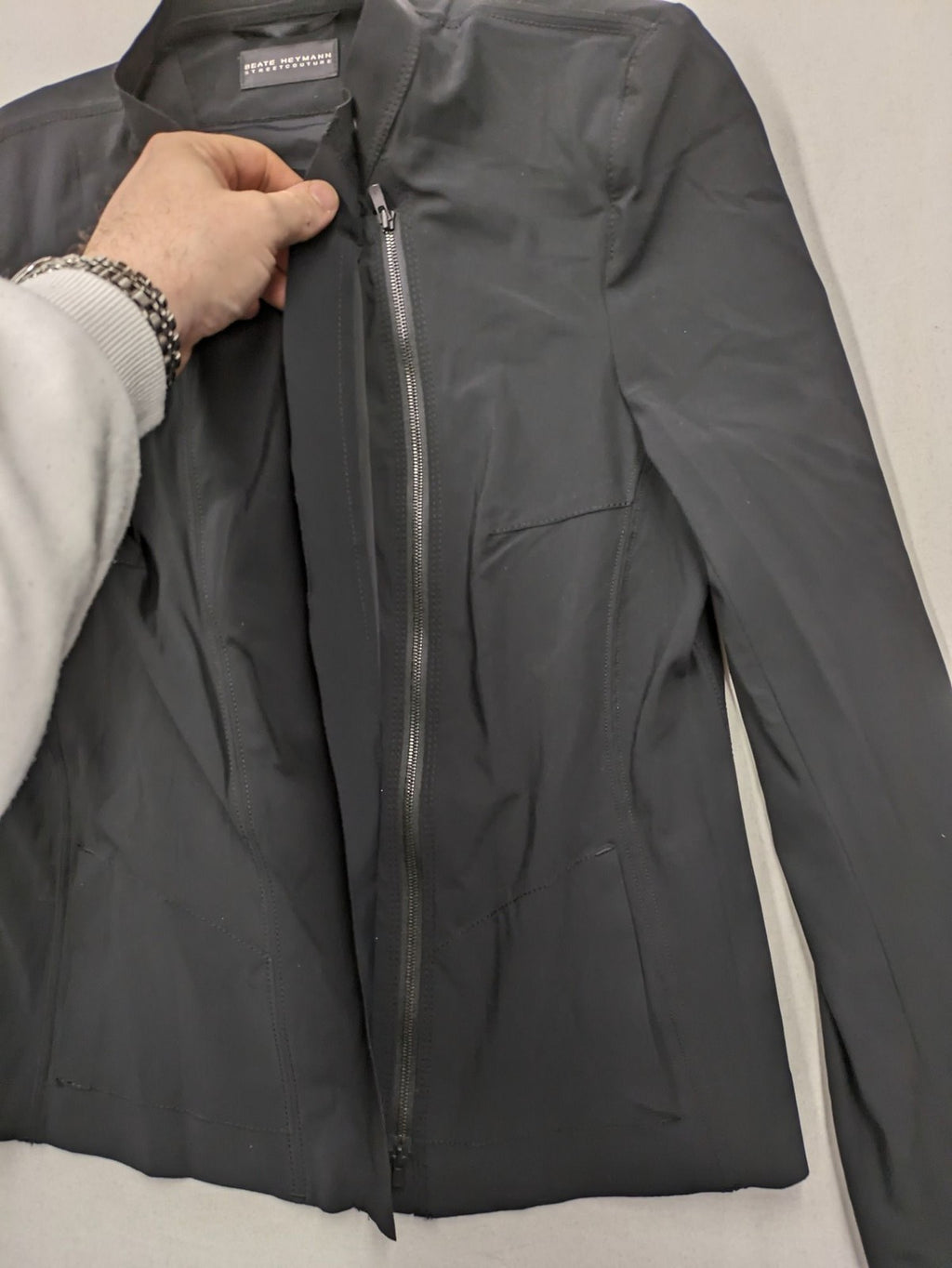 Beate Heymann black biker jacket with asymmetrical front and stand-up collar, stretch material.