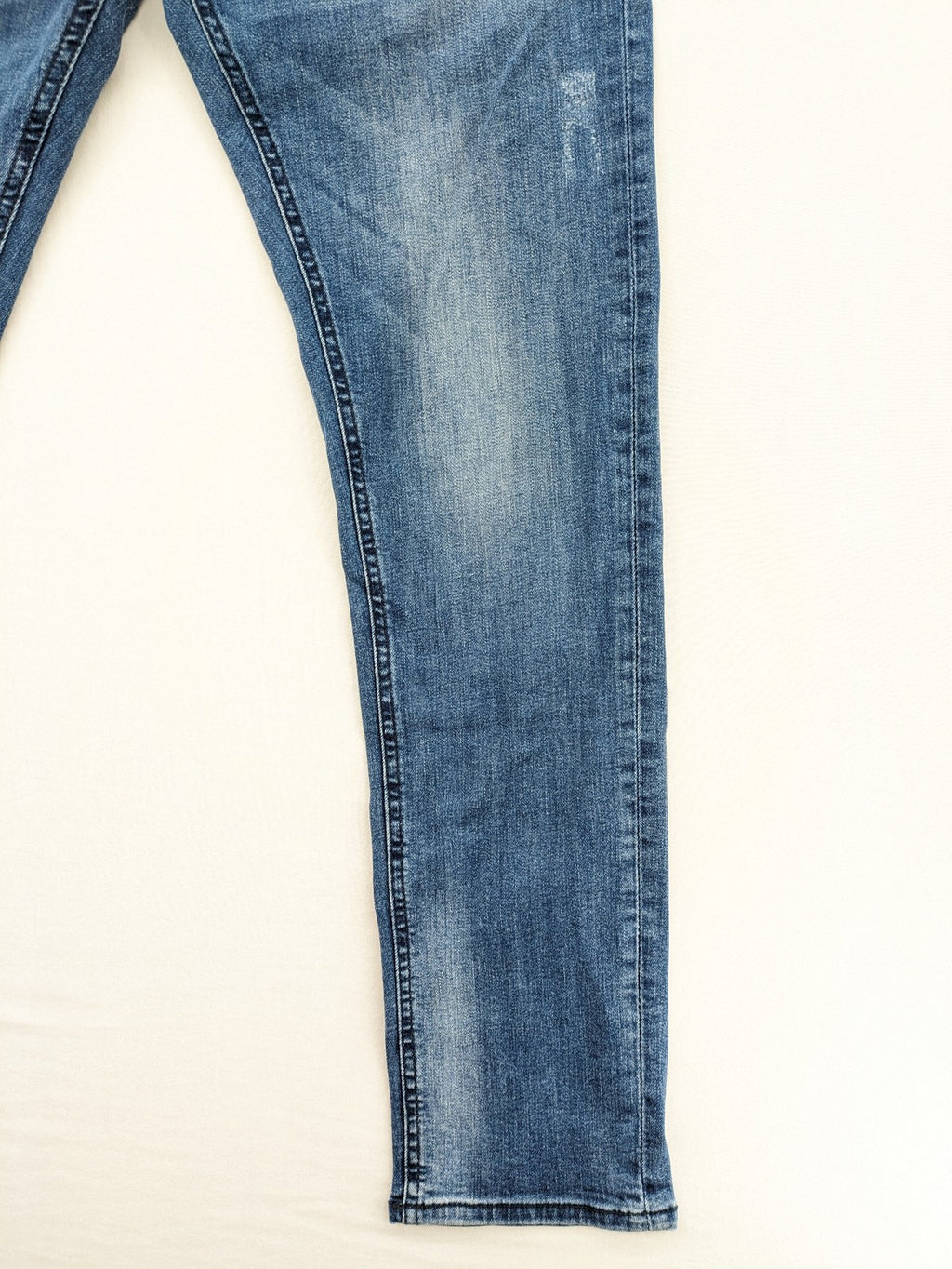 Crosshatch blue slim fit jeans with faded wash and logo patch on back pocket.