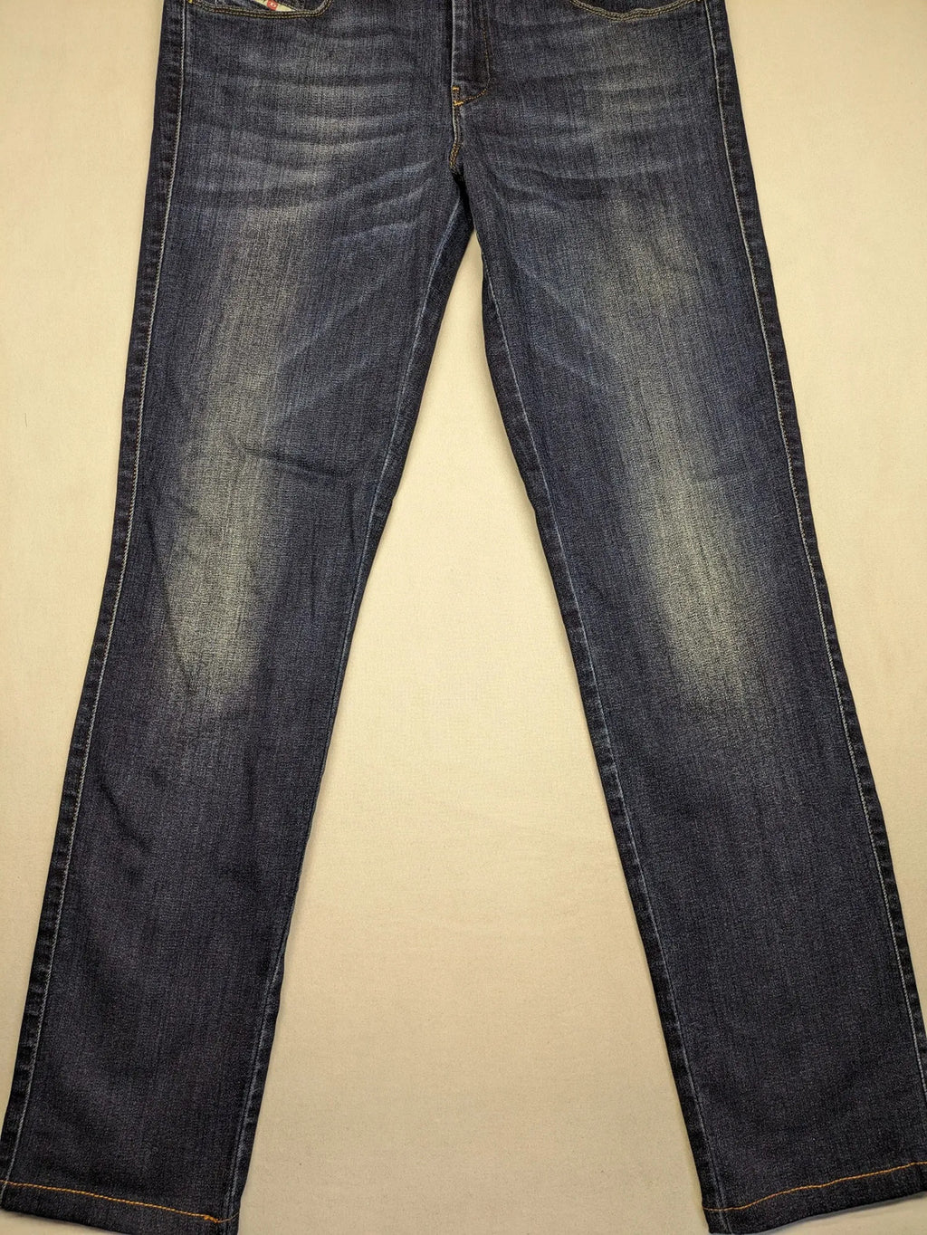 Diesel blue straight jeans with regular waist, dark wash, and stretch material.