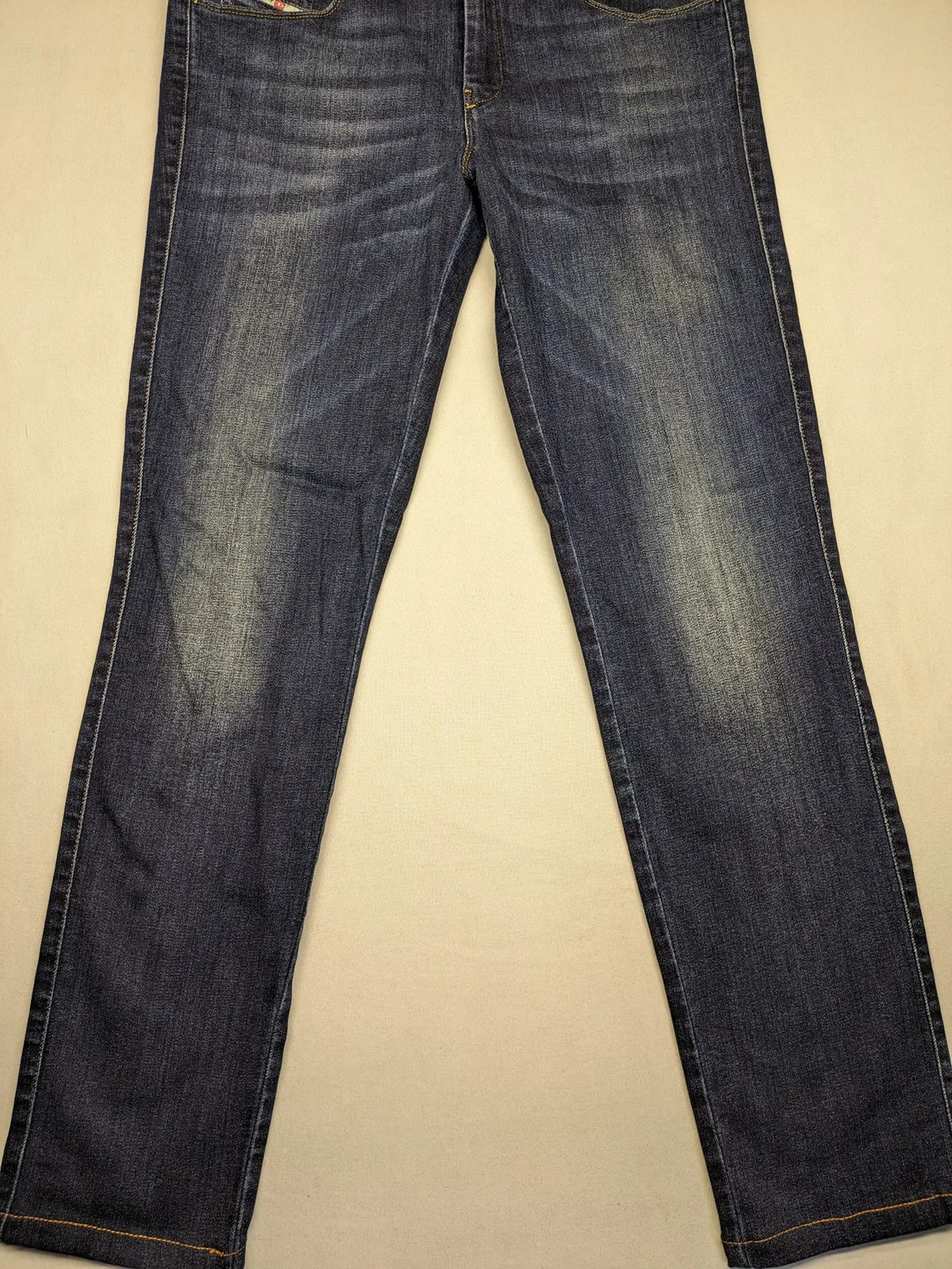 Diesel blue straight jeans with regular waist, dark wash, and stretch material.
