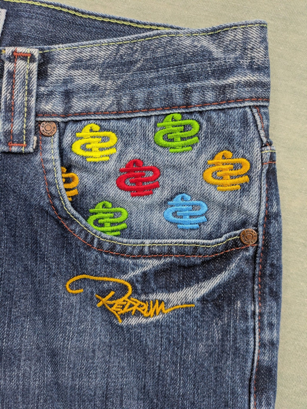 Y2K blue straight jeans with colorful logo embroidery and baggy fit.