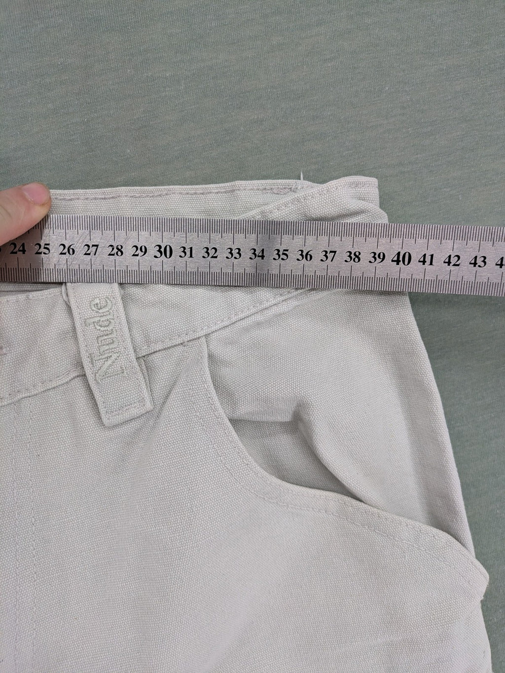 NUDE beige pants with double knee reinforcements and multiple utility pockets.