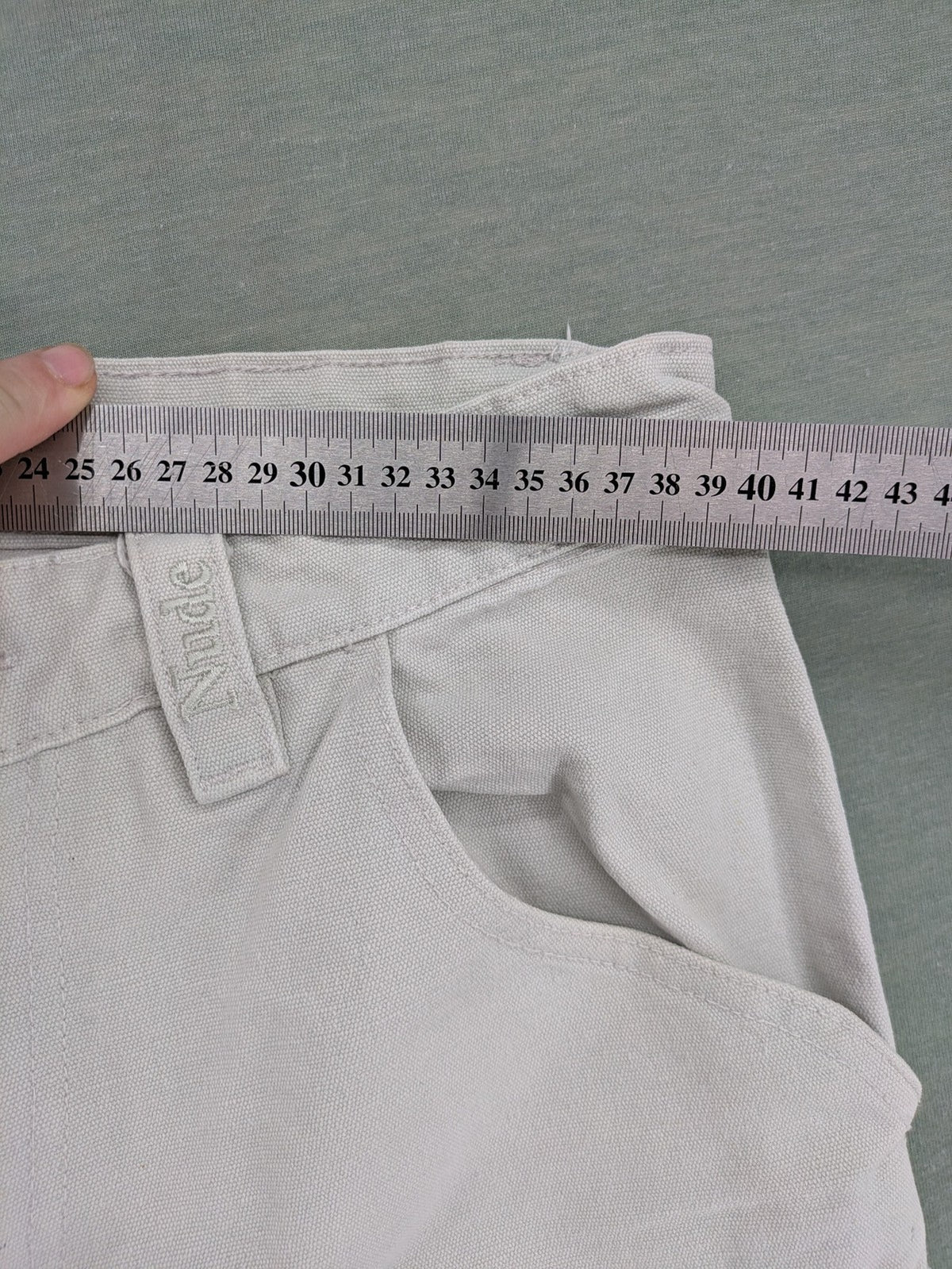 NUDE beige pants with double knee reinforcements and multiple utility pockets.