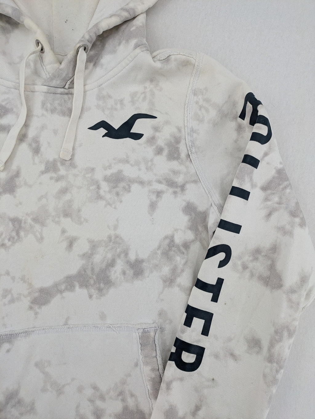 Hollister grey and white tie-dye hoodie with logo on chest, back, and sleeve.