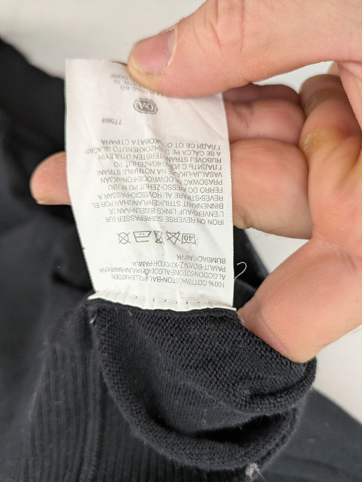 Angelo Litrico black knit jumper V-neck with tonal emblem and "Supreme Oil Quality" graphic.