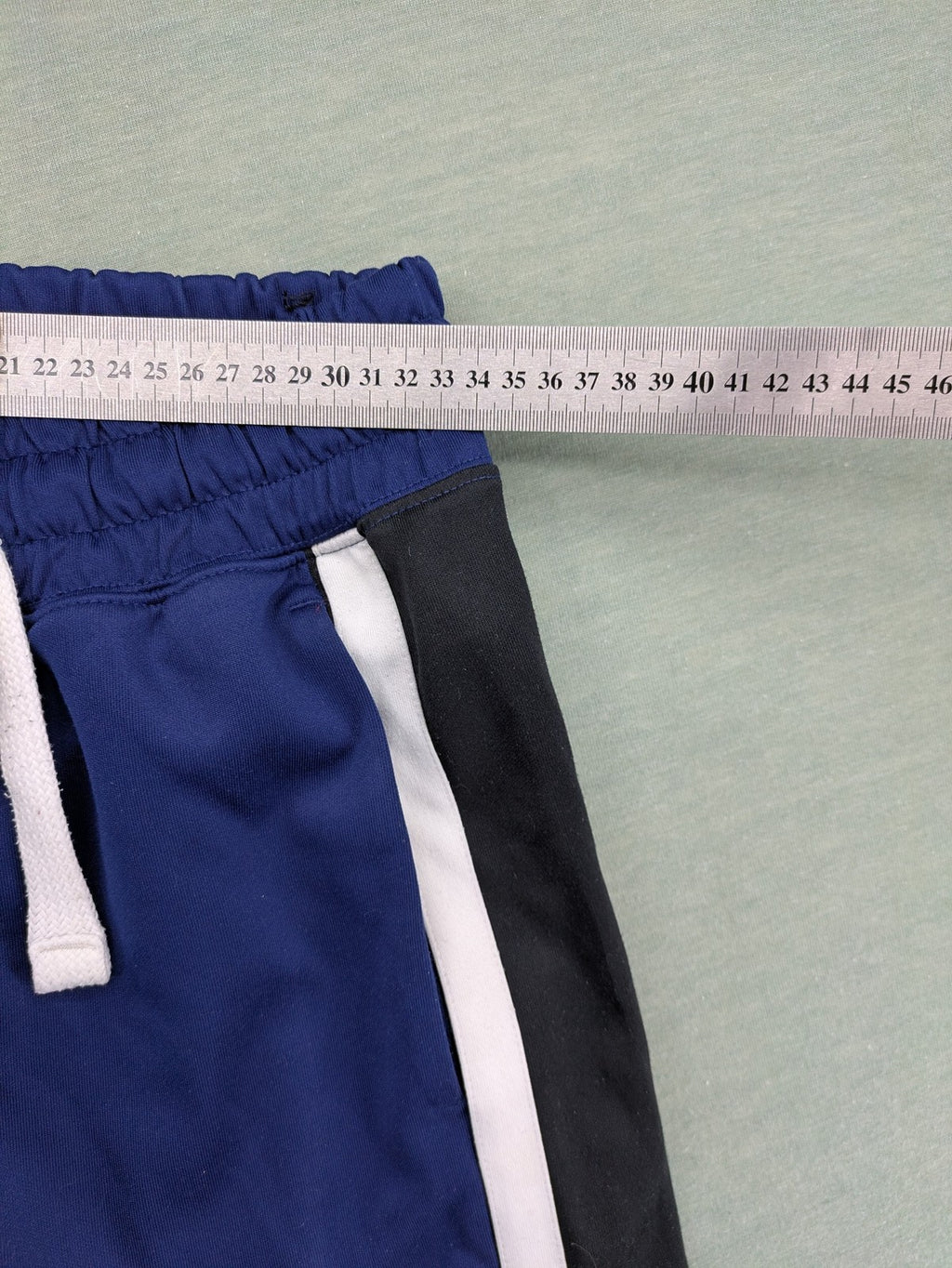 Nike Air blue jogging pants with black and white side stripes, elastic waistband.