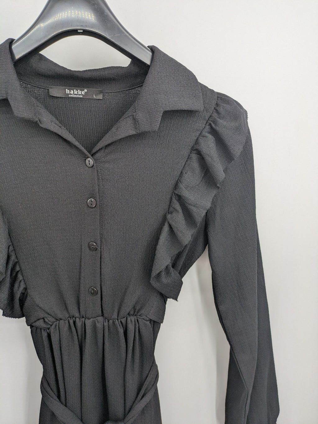 Hakke black maxi dress with ruffle details, long sleeves, and matching belt.