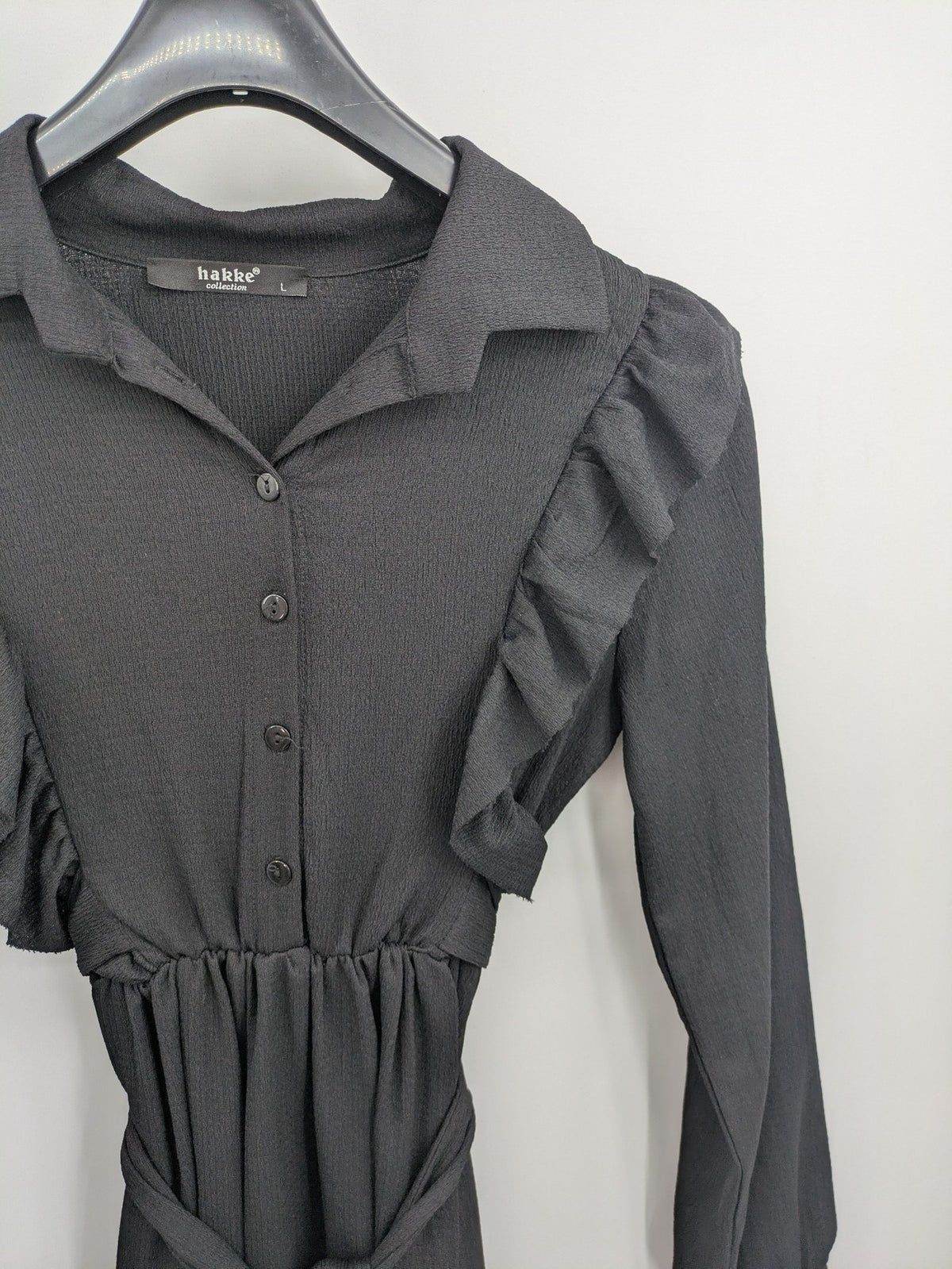 Hakke black maxi dress with ruffle details, long sleeves, and matching belt.