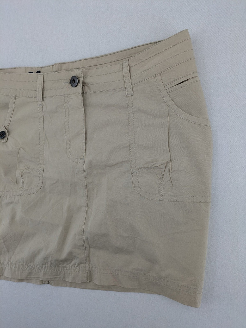 ESMARA beige cargo mini skirt with utility pockets and classic zipper button closure.
