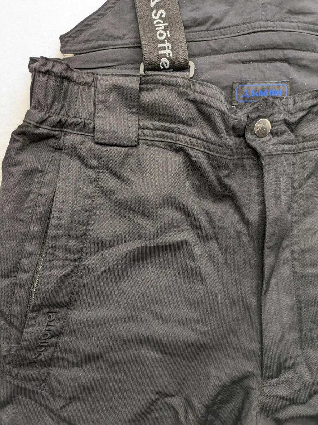 Schoffel black ski pants with adjustable straps, zip pockets, and snow gaiters.